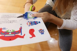 Bambina gioca con le pagine della brochure dedicata all'intrattenimento dei ragazzi.