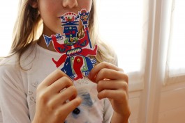 Bambina gioca con le pagine della brochure dedicata all'intrattenimento dei ragazzi.