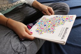 Brochure mostra Mauro Bubbico tenuta chiusa tra le mani di una bambina