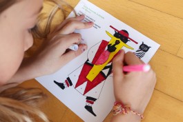 Bambina gioca con le pagine della brochure dedicata all'intrattenimento dei ragazzi.