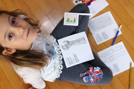 Bambina gioca con le pagine della brochure dedicata all'intrattenimento dei ragazzi.