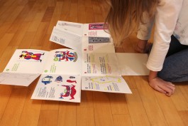 Brochure della mostra del designer Mauro Bubbico spiegata e appoggiata a terra.