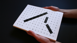 Mani che reggono il volume editoriale sul designer AG Fronzoni di cui si vede solo la copertina 